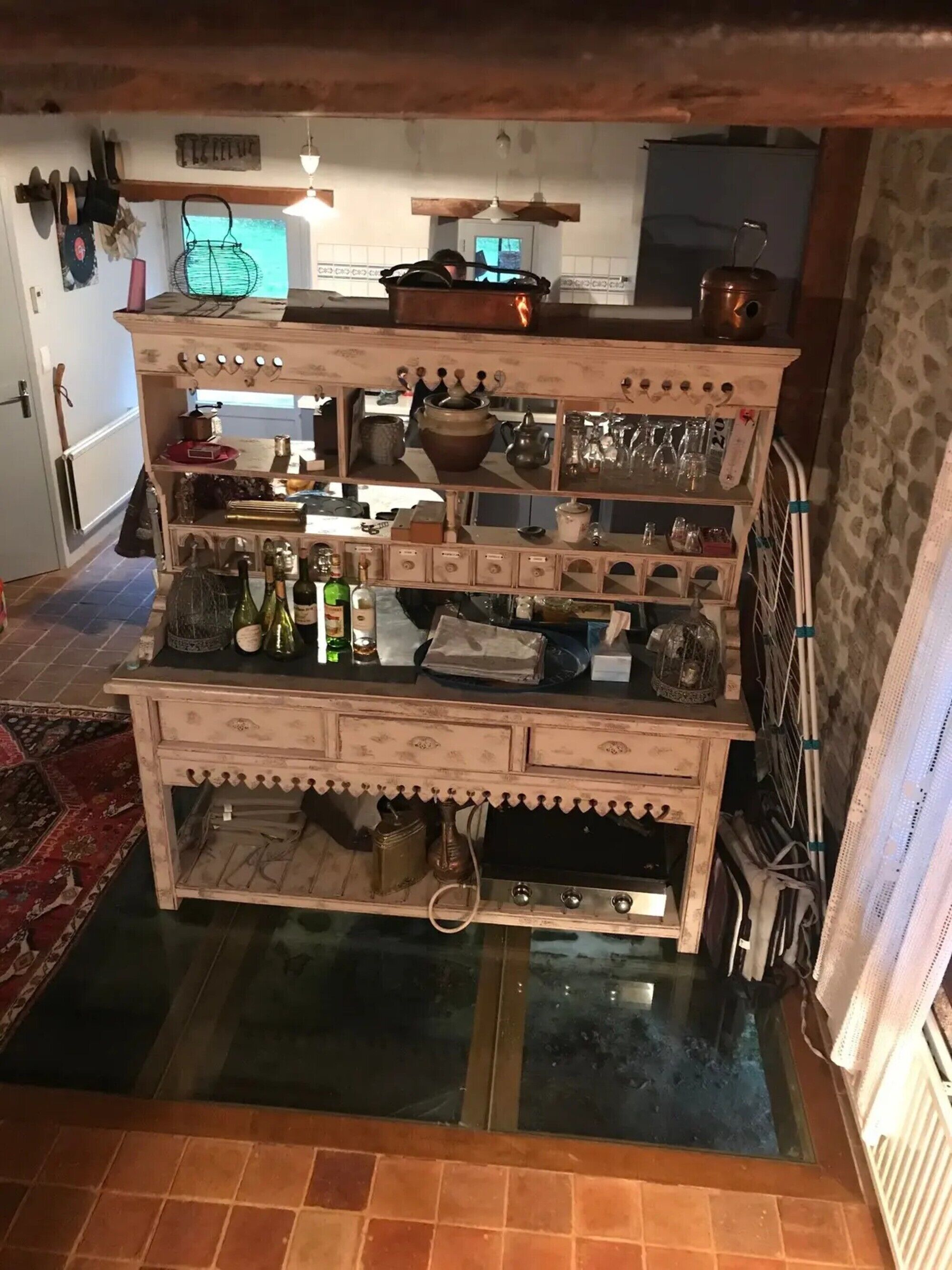 Une cuisine rustique avec un îlot central en bois, divers ustensiles de cuisine et une cuisinière.