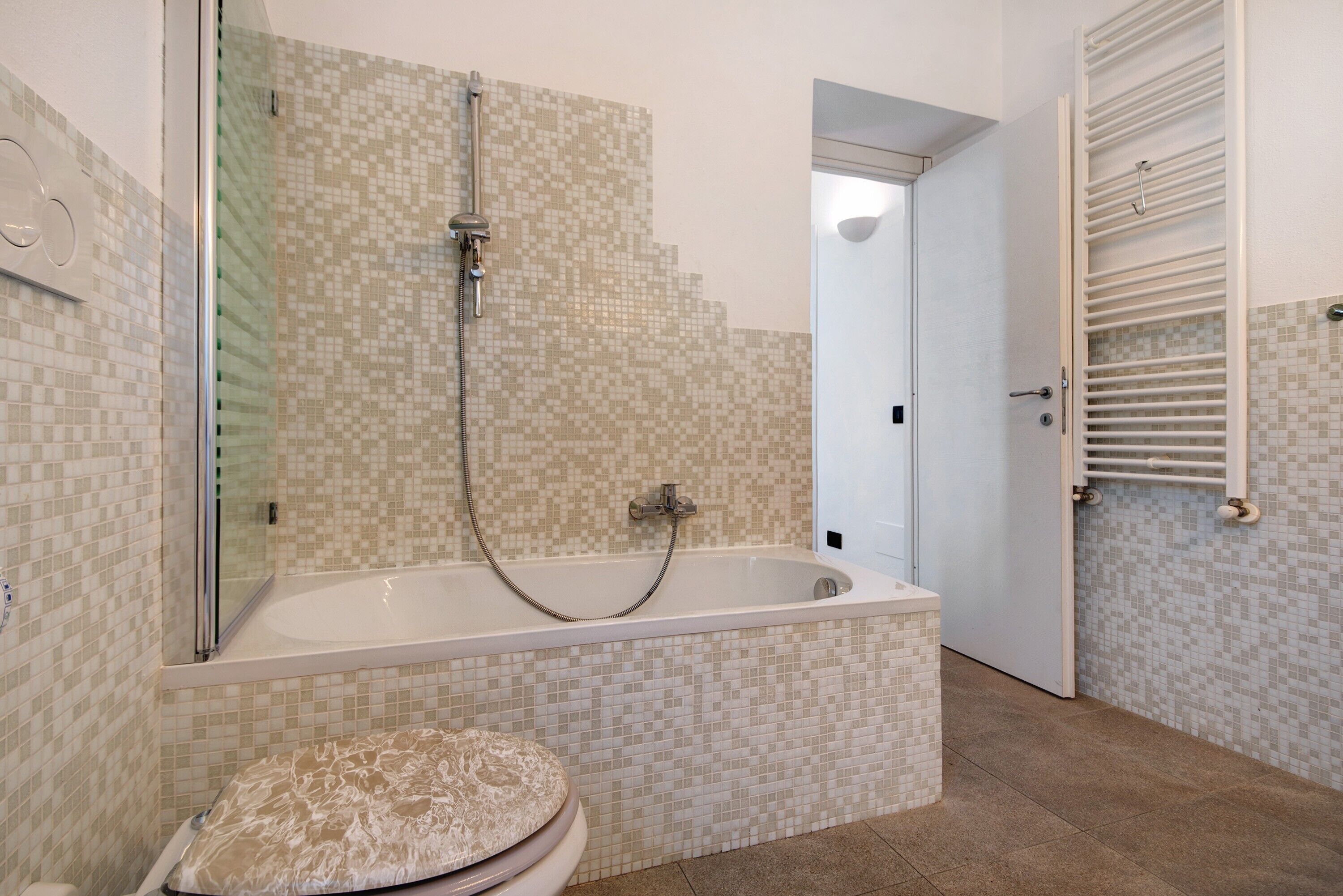 Une salle de bain avec une baignoire, une douche et des toilettes.