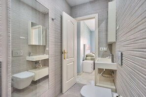 Ein modernes Badezimmer mit zwei Waschbecken, einer Toilette und einer Dusche.