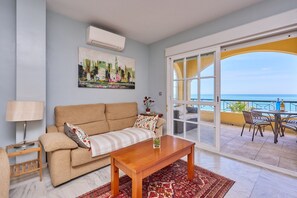 Un salon avec un canapé, une table basse et un tableau accroché au mur.