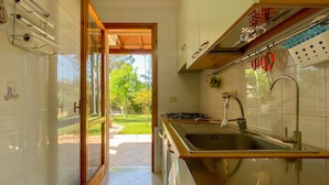 A kitchen with a sink, stove, and cabinets.