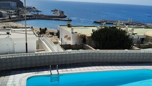 A swimming pool with a view of the sea and buildings. - Vacation Apartment 'Calipso Sun and Beach' with Sea View, Wi-Fi and Air Conditioning (Puertorico)
