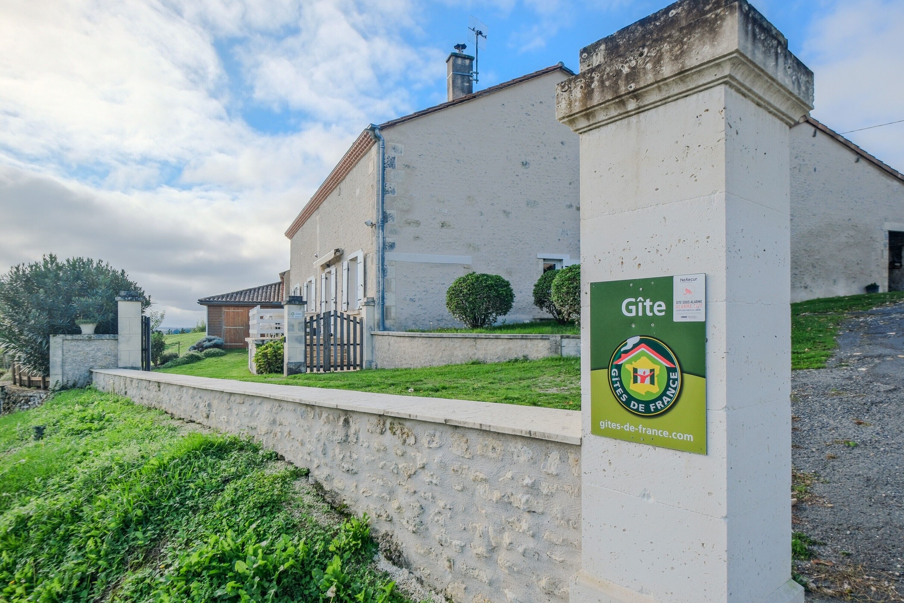 Un bâtiment portant une enseigne indiquant « Gîte » et affichant le logo de « Gîtes de France ».