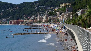 Une ville côtière dotée d’une plage, d’un littoral rocheux et de bâtiments construits sur une colline.