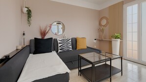 Een moderne woonkamer met een bank, een glazen salontafel en een groot raam.