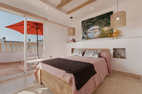 A bedroom with a bed, a large window, a balcony, and a painting on the wall.
