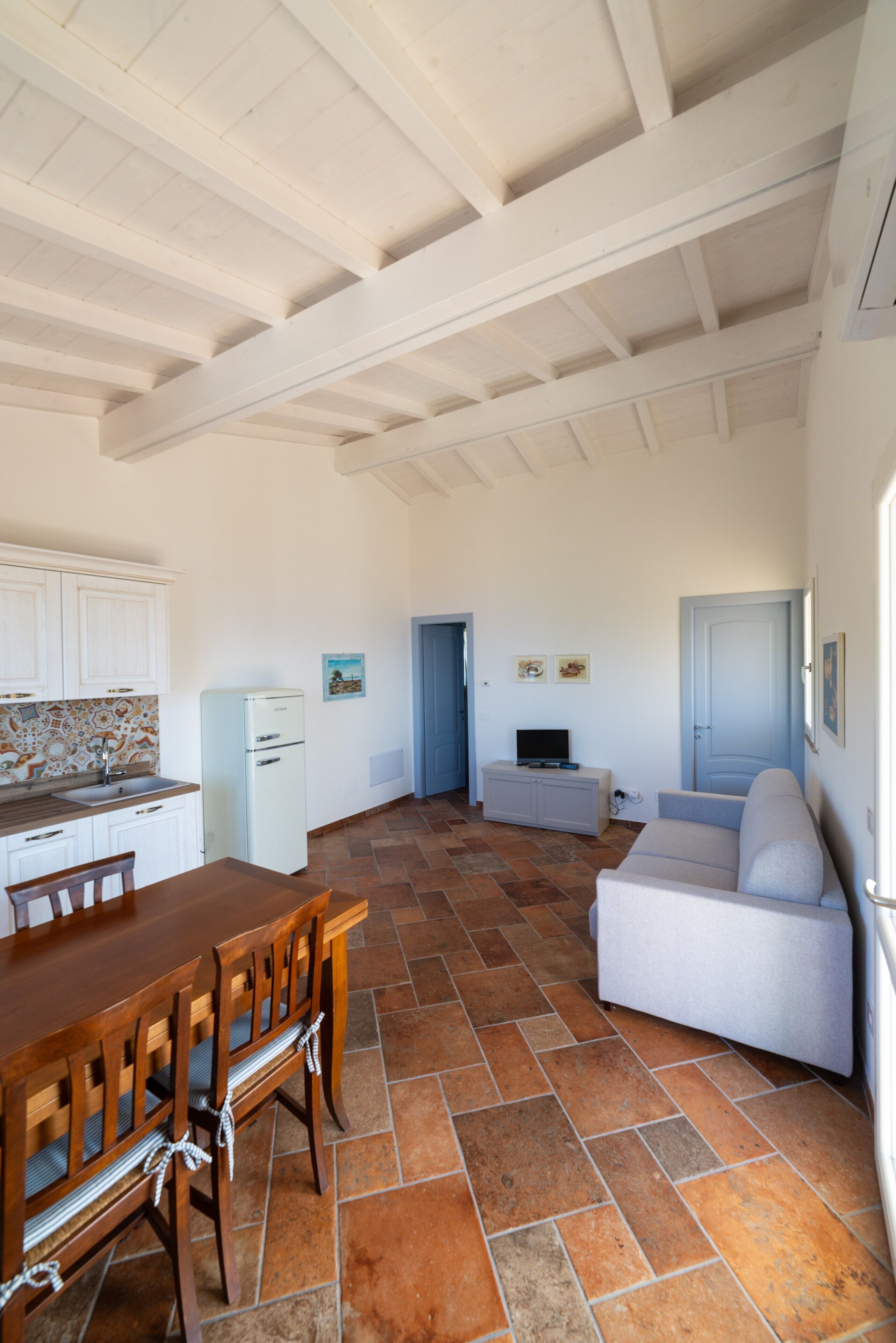 Un espacio habitable compacto con cocina, comedor y zona de estar.
