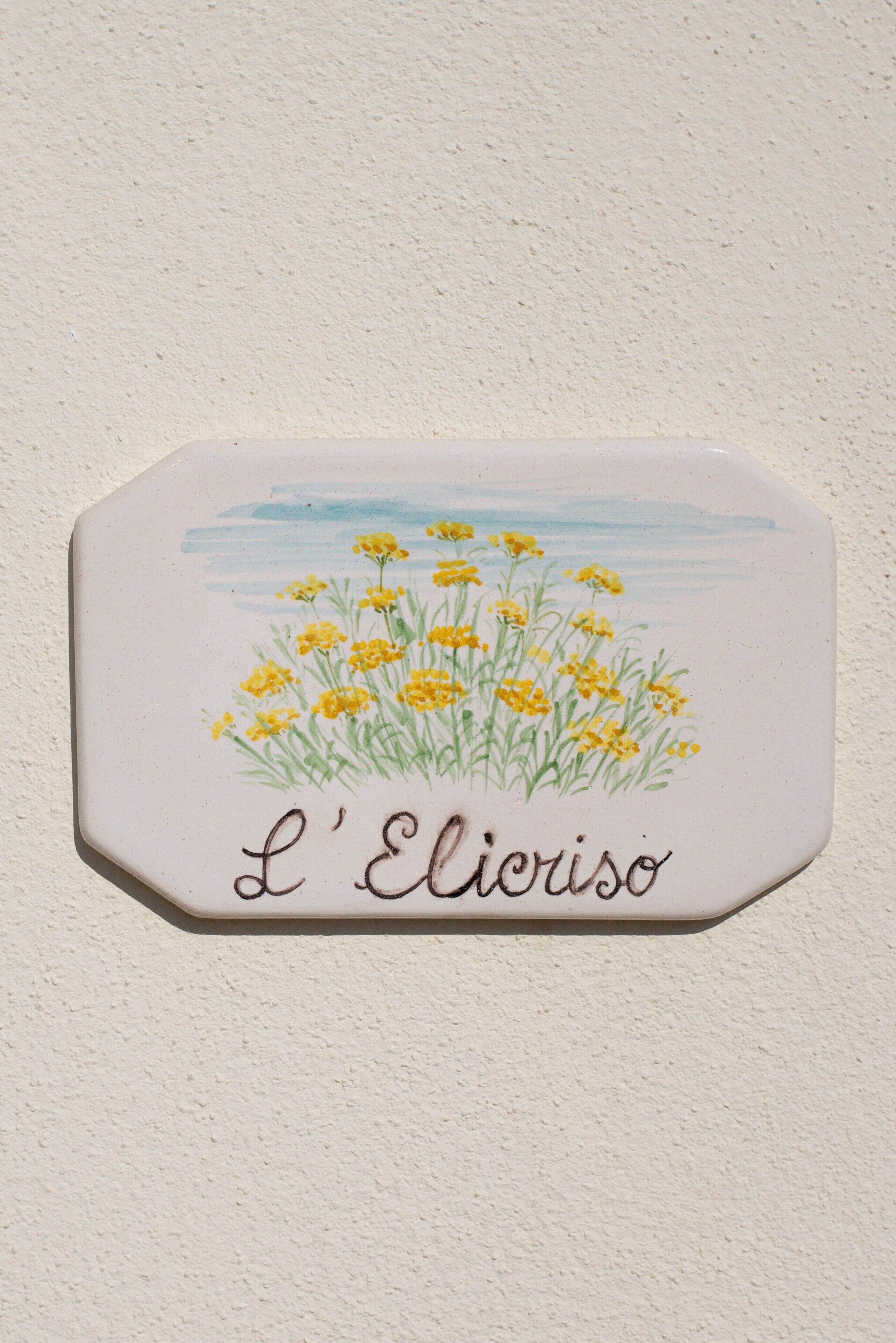 Un azulejo de cerámica con un diseño floral y el texto 'L'Elicriso'.