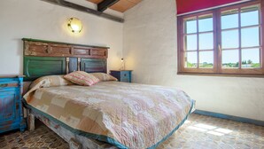 A bedroom with a bed, wooden headboard, nightstands, a window, and a tiled floor. - Holiday Home 'Mora' with Private Terrace, Private Garden and Wi-Fi (Vejer de la Frontera)