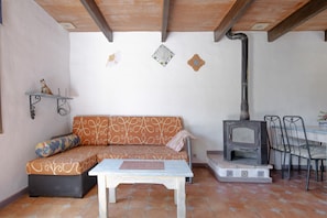 Une pièce comprenant un canapé, une table, une cheminée et une étagère fixée au mur.