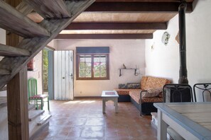 Une pièce avec un escalier en bois, un canapé, une table et une fenêtre donnant sur un beau paysage.