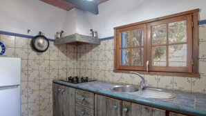 A kitchen with a wooden cabinet, a sink, a window, and a stove. - Holiday Home 'Mora' with Private Terrace, Private Garden and Wi-Fi (Vejer de la Frontera)