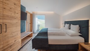Un dormitorio moderno con cama, armario de madera y vistas al exterior.
