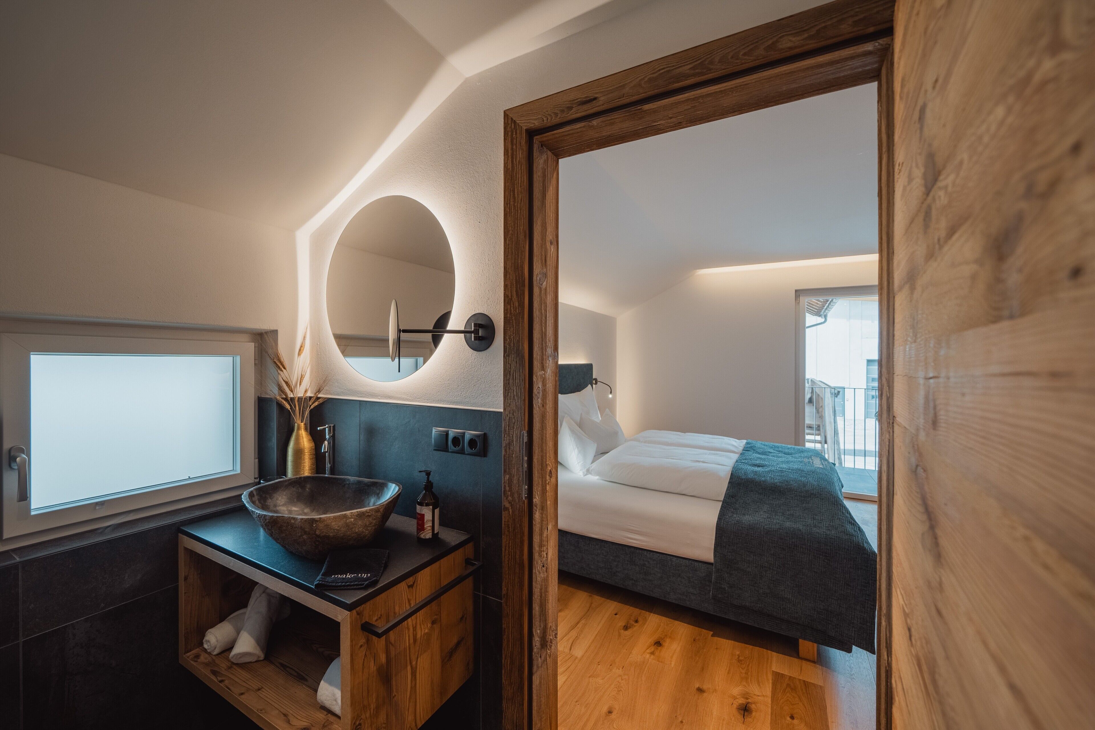 A modern bedroom with a wooden bed, a bedside table, and a large mirror.