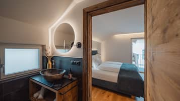 A modern bedroom with a wooden bed, a bedside table, and a large mirror.