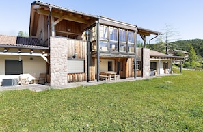A two-story building with a stone facade, large windows, and a balcony. - Holiday Home 'Lexn Radein' with Mountain View, Wi-Fi and Air Conditioning (Radein)
