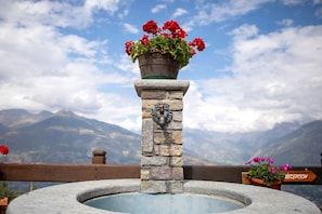 A stone fountain with a sign indicating 'RECEPTION' and a wooden railing.