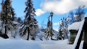 A snow-covered outdoor area with stone walls and a wooden railing. - Apartment 'Elois' with Mountain View, Shared Terrace and Wi-Fi (Gressan)