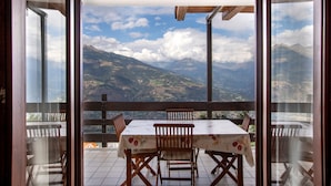 A balcony with a table and chairs, offering a mountain view. - Apartment 'Sylvie' with Mountain View, Shared Terrace and Wi-Fi (Gressan)
