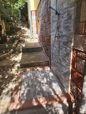 A stone staircase leading to a door with a hose attached to the wall. - Aventino Gutturu Holiday Home with Sea View, Private Terrace and Garden (Gutturu)