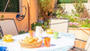 A table set outdoors with a checkered tablecloth, a basket of pastries, and various cups and a pitcher. - Holiday Home 'Villa Sunset' with Sea Views, Wi-Fi and Air Conditioning (Calafell)