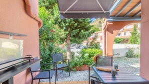 An outdoor patio with a grill, chairs, and a table with drinks. - 'Meu Descan' Apartment with Shared Pool, Private Terrace, and Air Conditioning (Cerbère)