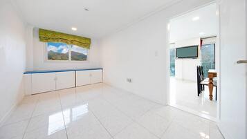 A spacious room with a large window, a blue countertop, and a view of mountains.