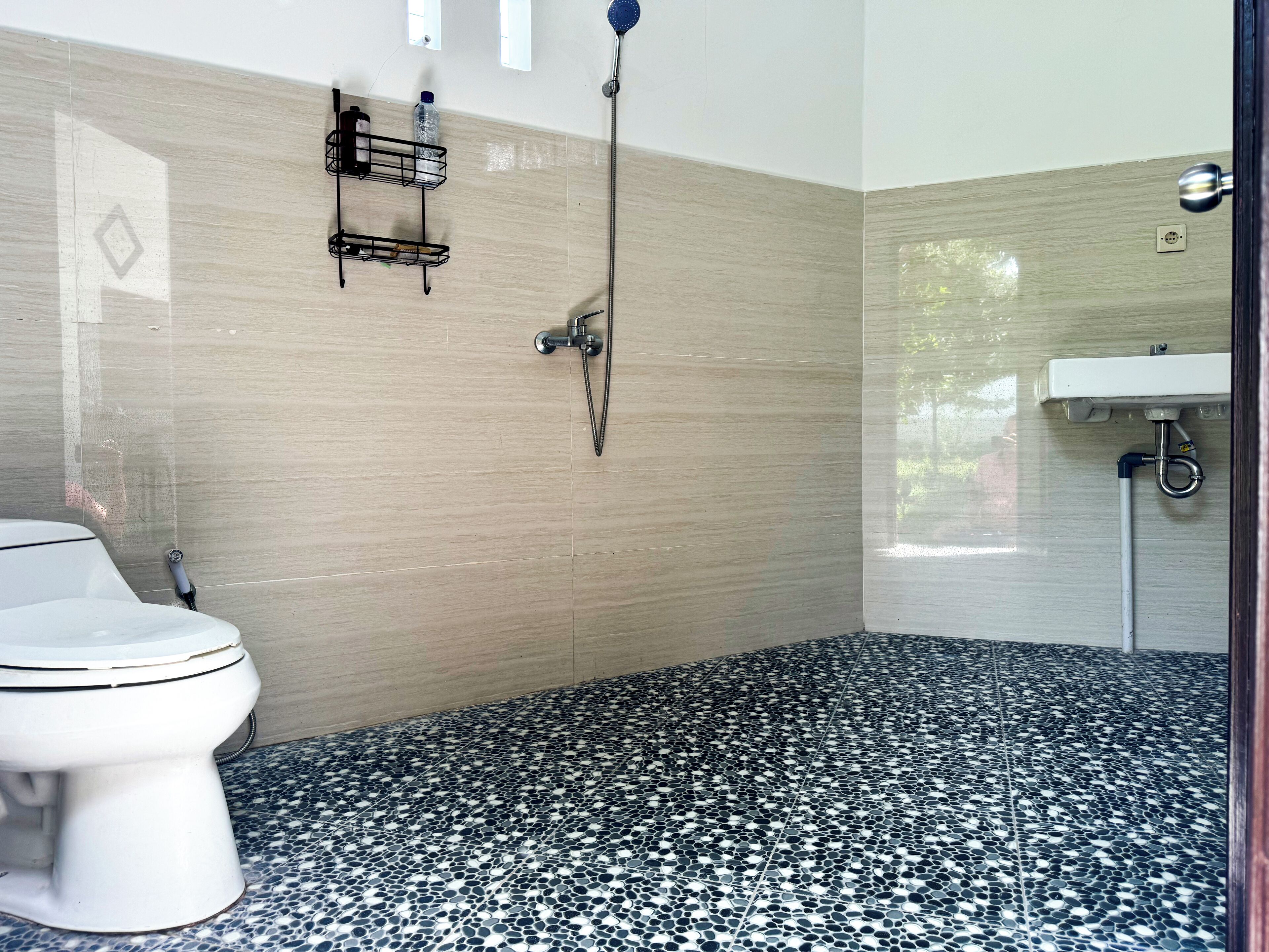 A bathroom with a toilet, a shower, and a sink.