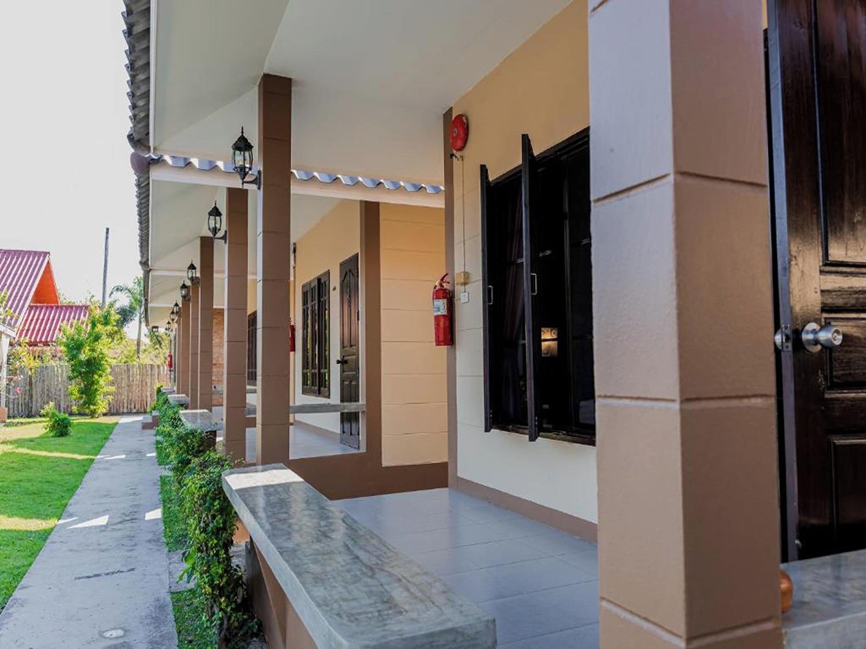 A building with a covered outdoor area, a fire extinguisher, and a door.