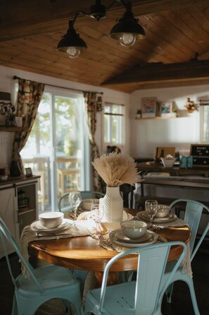 Comedor con una mesa de madera dispuesta para cuatro personas, rodeada de sillas azul claro.