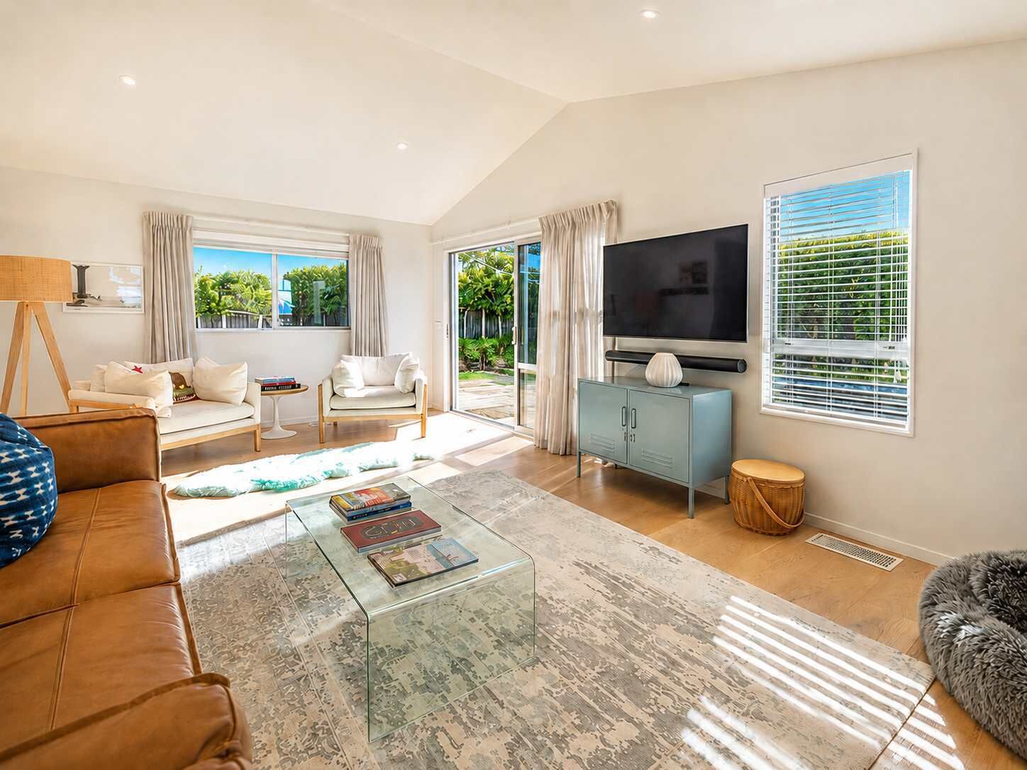 A spacious living room with a sofa, coffee table, and TV.