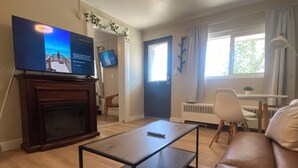 A living room with a TV, sofa, coffee table, and a fireplace.