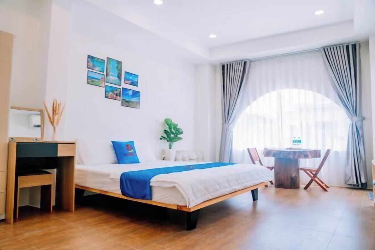 Un dormitorio moderno con una cama de madera, un escritorio y una mesa de comedor.