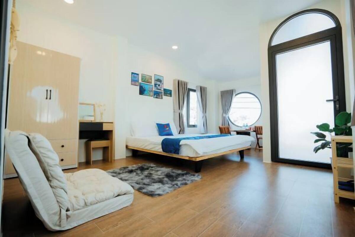 Un dormitorio moderno con cama, escritorio, silla y armario.