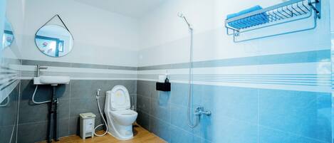 A bathroom with a toilet, sink, and shower.