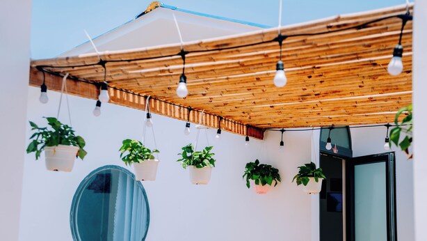 A covered outdoor area with hanging plants and string lights. - Thuyen Xua Homestay Phu Quy Island (Phu Quy)