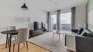 Una sala moderna con un sofá, una mesa de comedor y un televisor.