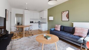 Un appartement moderne comprenant un coin repas, une cuisine et un salon.