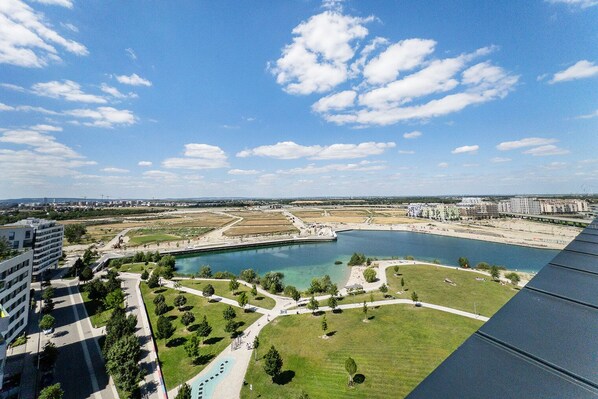 A high-rise hotel with a view of a large body of water, green spaces, and surrounding buildings.