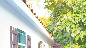 A narrow pathway leading to a white building with multiple windows, a tiled floor, and a white picket fence. - The Tiny cottage in quite charming. Palos Verdes with AC, WiFi and washer/dryer  (Rancho Palos Verdes)