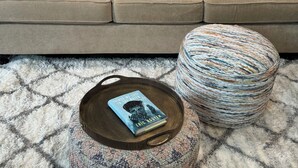 A beige sofa with patterned cushions and a round ottoman with a book on it. - The Tiny cottage in quite charming. Palos Verdes with AC, WiFi and washer/dryer  (Rancho Palos Verdes)