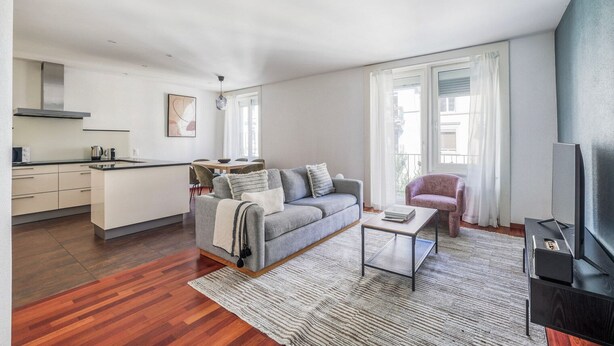 A modern apartment with a kitchen, dining area, and living room.