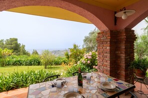 An outdoor dining area with a table set for two, a bottle of champagne, and a view of the sea. - Cozy 90m2 apartment, able to accommodate up to 4 guests, located in a panoramic area above Imperia, surrounded by olive trees. The view from the terrace is magnificent!The accommodation is equipped with every comfort, including the presence of an outdoor (Imperia)