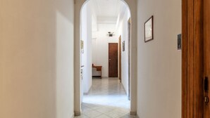 A hallway with a tiled floor, a wooden door frame, and a door. - GuestHost - Piazza Nievo in Trastevere Cozy Apartment (Roma)