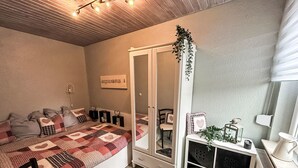 Ein gemütliches Schlafzimmer mit einem Bett, einer Kommode und einem Schminktisch.