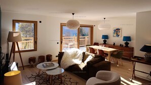 A modern living room with a sofa, coffee table, and dining area. - Paradiski new, quiet and sunny Plan peisey (PEISEY-NANCROIX)