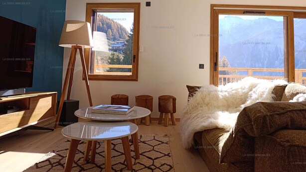 A modern living room with a television, a lamp, a table, and a sofa. There are windows with mountain views. - Paradiski new, quiet and sunny Plan peisey (PEISEY-NANCROIX)