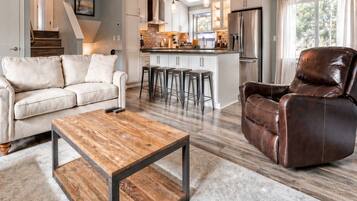 A modern living room with a sofa, coffee table, and leather chair.
