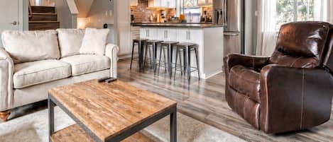 A modern living room with a sofa, coffee table, and leather chair.