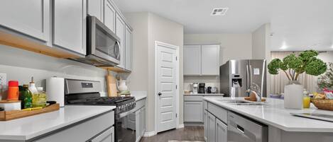 A modern kitchen with stainless steel appliances, a microwave, and a coffee maker.